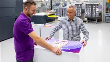 Pracownik Drukuj Sam z klientem przeglądają profesjonalne wydruki